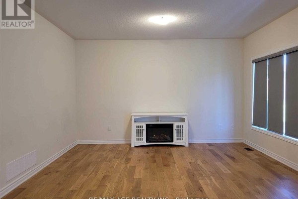 Living room with hardwood floors, neutral walls, and an electric fireplace console. - 34 Furniss Street, Brock