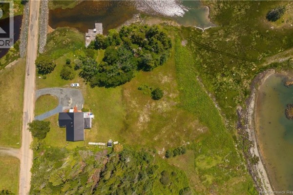 Overhead aerial view of 34 Leavitt Head Road, Back Bay, showing the house, driveway, surrounding grassy lot, and adjacent water inlets. - 34 Leavitt Head Road, Back Bay