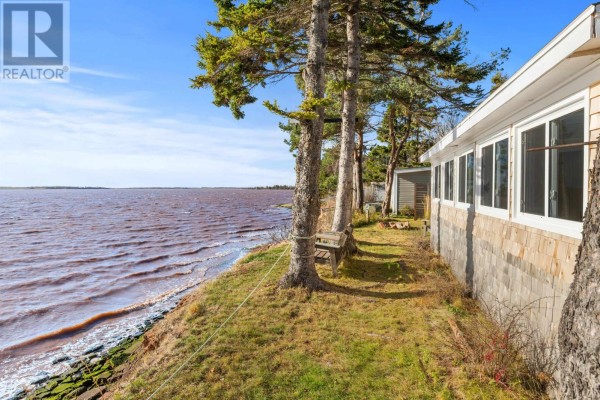 Aerial view of waterfront property with multiple buildings, trees, and water. - 34 Margaret Lane, Stavert Shore, North Bedeque