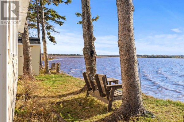 Small kitchen with white cabinets, wooden countertops, stainless steel sink, and dark floor. - 34 Margaret Lane, Stavert Shore, North Bedeque