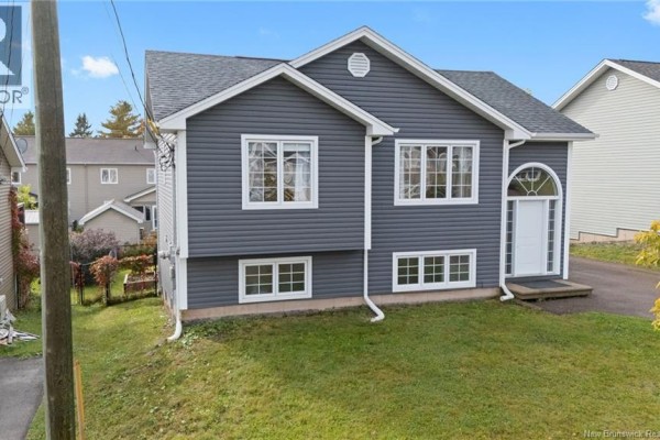 Front exterior of a grey multifamily house with white trim windows and a white front door. - 34 Monique Street, Moncton