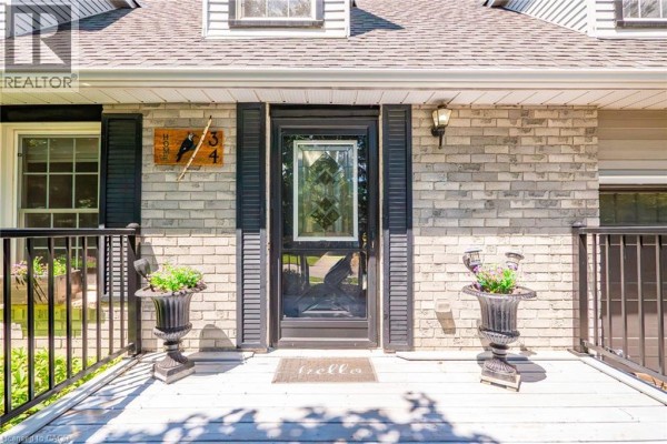Front door and porch area of a residential house with decorative urns and house number signage. - 34 Peachtree Crescent, Cambridge