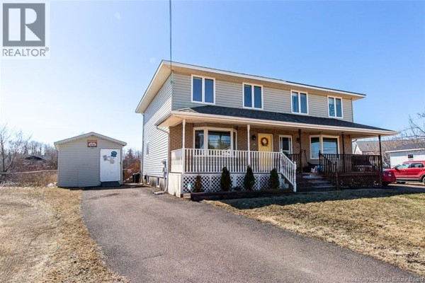Side view of the house showing the driveway, shed, and neighboring properties. - 34 Rennick Road, Moncton