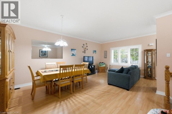 Dining table with chairs and a sofa in the living room. - 34 Southbrook Drive Unit# 7, Binbrook