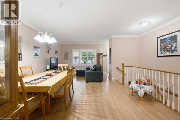 Open concept living and dining area with hardwood floors and a staircase. - 34 Southbrook Drive Unit# 7, Binbrook