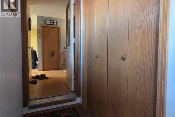 Hallway entrance with light wood closet doors and a view into a living area with a wood floor. - 34 Stanley Street, Creelman