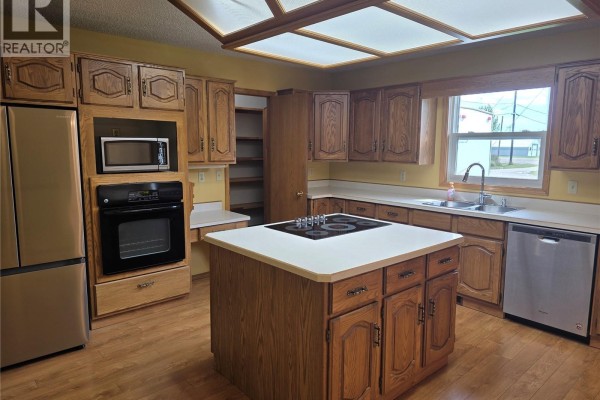 Laundry room with a washer, dryer, and wood cabinets, showing a doorway to another room. - 34 Stanley Street, Creelman