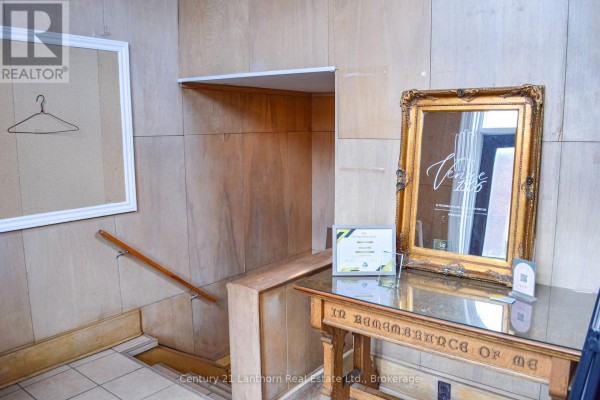 Interior view of a wooden hallway with a staircase, a decorative mirror, and a framed certificate. - 34 Victoria Avenue, Belleville