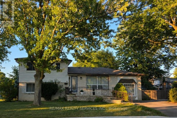 Residential house exterior with brick and white siding, large trees in front yard. - 34 Watson Crescent, Brampton