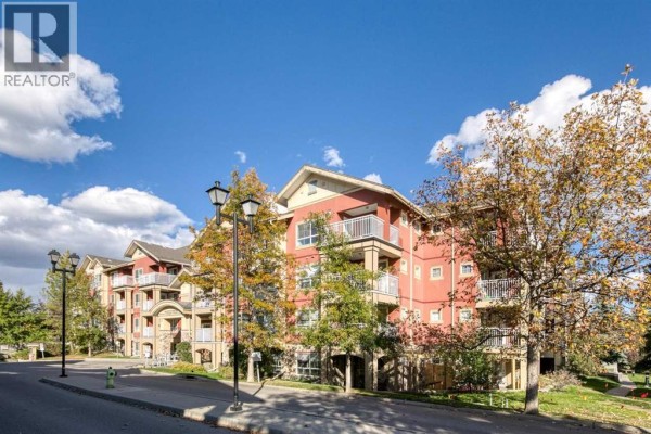 Exterior of a red multi-story building with balconies and trees in the foreground. - 340, 22 Richard Place Sw, Calgary