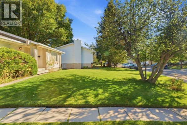 View of the bungalow's front entrance from the street, showing manicured landscaping. - 340 Canniff Place Sw, Calgary