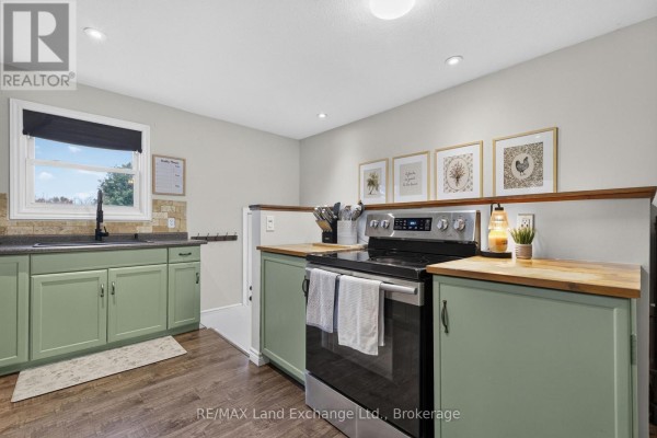 Kitchen featuring green cabinets, wooden countertops, a stainless steel stove, and decorative framed art on the wall. - 3400 Highway 9 Highway, Brockton