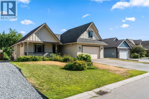 Side view of a beige house with a double garage and grass yard. - 3404 Mckechnie Drive, Armstrong