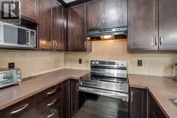 Open-concept living area showing the kitchen, dining area, and hallway. - 3407, 10 Country Village Park Ne, Calgary