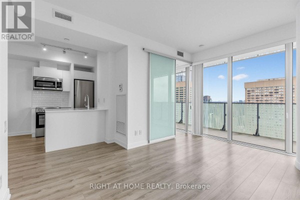 Open-concept living area and kitchen with stainless steel appliances and island. - 3408 - 42 Charles Street E, Toronto