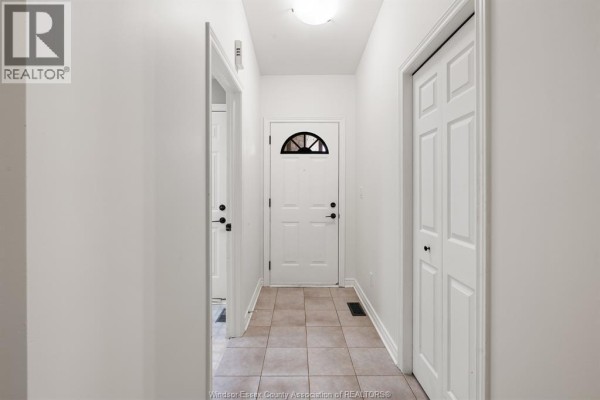 Hallway inside the townhouse with tiled floor and white doors. - 341 Rockport Lane, Kingsville