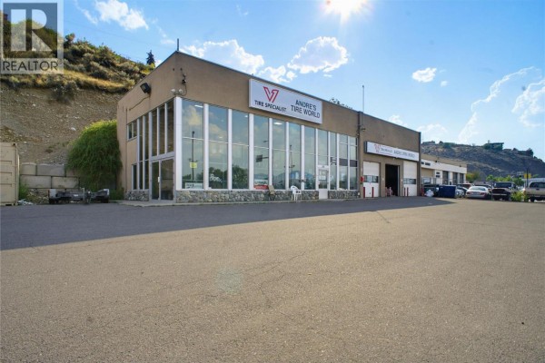 Wide exterior shot of commercial building with parking lot in foreground. Sun shining brightly in the sky. - 341 Victoria Street W, Kamloops