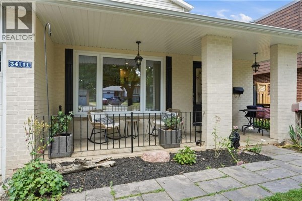 Close-up of the front porch with seating, planters, and decorative elements. - 3411 Lansdown Drive, Burlington