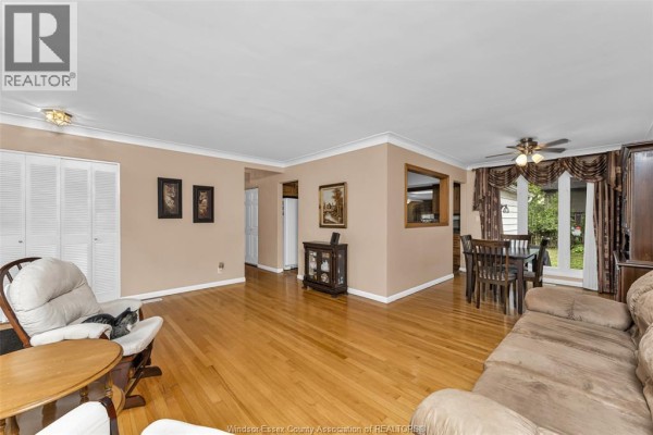 Living room and dining area with hardwood floors, beige walls, sofas, chairs, and a dining table. - 3415 Randolph, Windsor