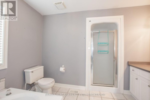 Open concept kitchen and living area with hardwood floors and a fireplace. - 3417 Michelle Court, Niagara Falls