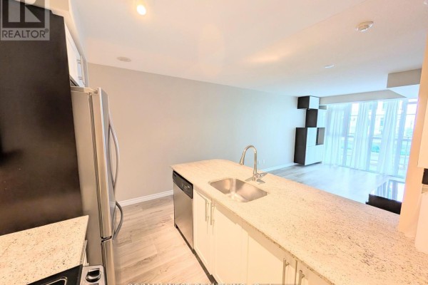 View of an open-concept living area with a kitchen island and large windows. - 342 - 38 Grand Magazine Street, Toronto