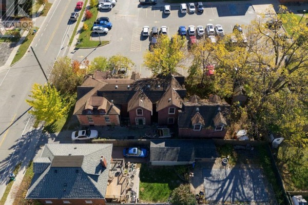 Angle view of brick house with gravel driveway and parked cars - 342 Mary Street N, Oshawa