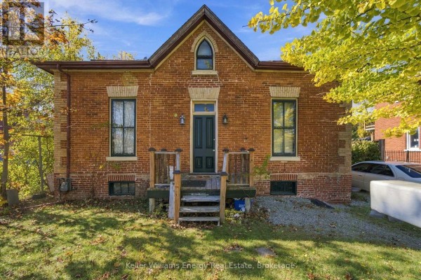 Side view of brick house with autumn leaves and nearby vehicles - 342 Mary Street N, Oshawa