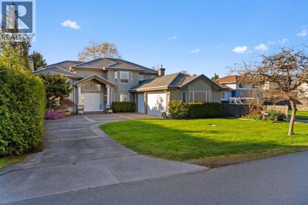 Front view of a residential property with a long driveway, manicured lawn, and mature trees. - 3420 Rosamond Avenue, Richmond