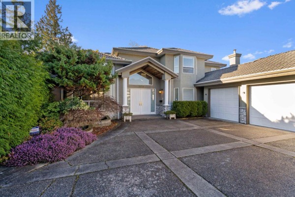 Close-up front view of a residential home entrance with double white doors, columns, and a paved driveway. - 3420 Rosamond Avenue, Richmond