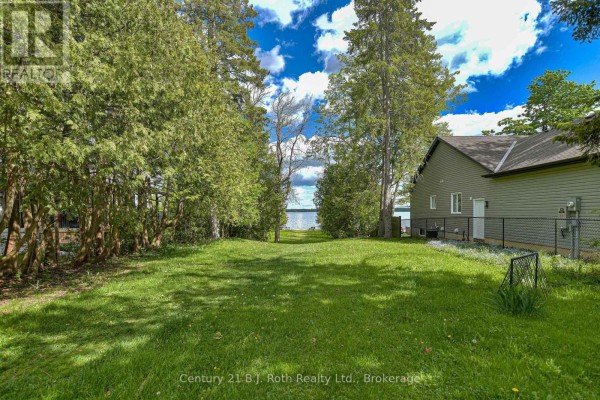 A grassy backyard with trees and a view of the lake. - 3427 Coronation Avenue, Severn