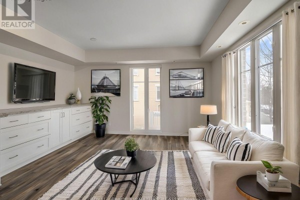 Living and dining area with a brown leather sofa, accent chairs, dining table, and windows. - 343 - 30 Western Battery Road, Toronto