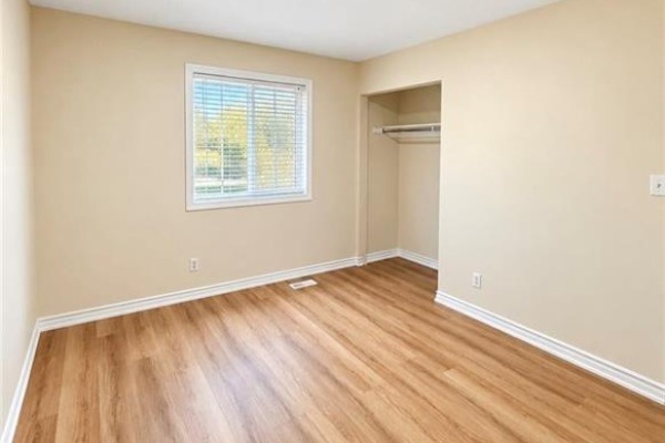 Bedroom with a window, neutral walls, laminate flooring, and open closet. - 343 Dalhousie Street, Brantford