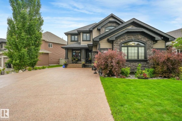 Side aerial view of the residence, showcasing the driveway, landscaping, and neighboring homes. - 3435 West Landing Ld Nw, Edmonton