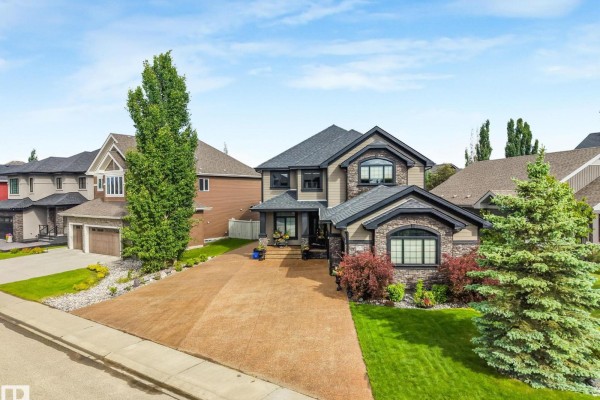 Close-up of the front entrance with a covered porch, dark columns, and double garage doors. - 3435 West Landing Ld Nw, Edmonton