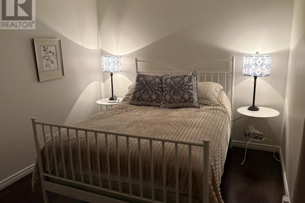Bedroom with a white metal bed frame, two bedside tables, and lamps. - 345 - 11 Harbour Street W, Collingwood
