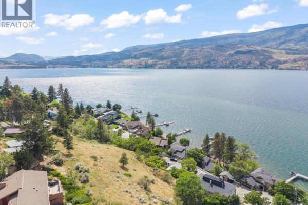 Aerial view of a lakeside neighborhood with a wide expanse of water and mountains. - 345 Poplar Point Drive, Kelowna