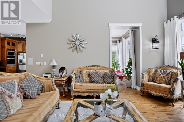 Living room with ornate sofas, glass coffee table, and sunroom view - 345305 15th Side Road Amaranth