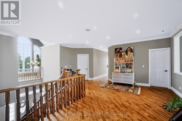 Hallway with hardwood floors, wooden banister, and arched window - 345305 15th Side Road Amaranth