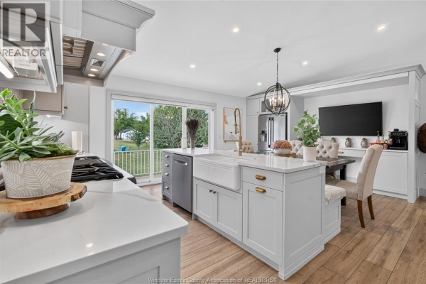 Modern kitchen with island, farmhouse sink, and backyard view - 346 Texas Road Amherstburg
