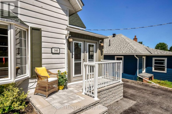 Close-up of front porch with wicker chair and potted plant. - 346 Yonge Street, Midland