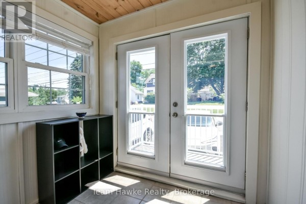 Interior view of mudroom with double glass doors and shoe rack. - 346 Yonge Street, Midland