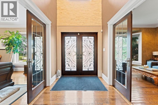 Foyer with double glass doors, decorative wrought iron double front doors, and hardwood floors. - 3460 Huntington Avenue, Windsor