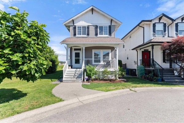 A two-story house with a grey facade, white trim, and a covered front porch. - 34609 7 Avenue, Abbotsford