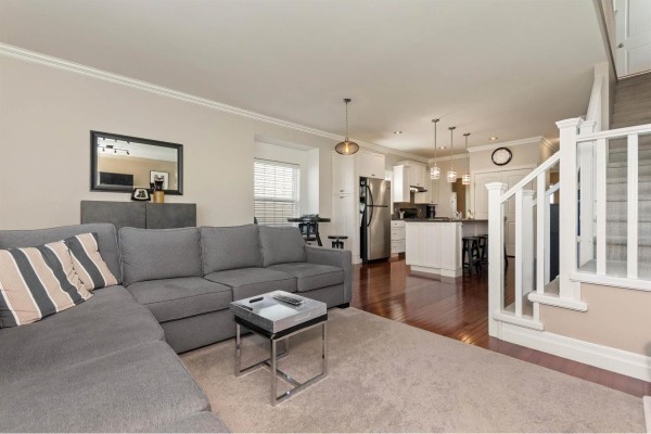 A wooden deck with a white pergola, outdoor seating, and a view of a grassy yard. - 34609 7 Avenue, Abbotsford