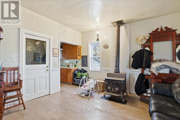 Entryway with sliding glass doors, coat hooks, and a vintage wooden bench. - 349 20 Side Road, Kincardine