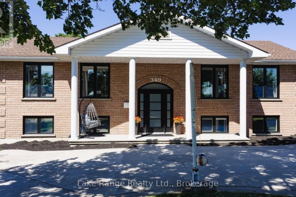 Close-up of the brick house entrance with large windows and porch swing. - 349 South Delhi Street, Huron Kinloss