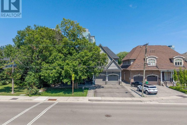 Aerial view of a street with houses, large trees, and city buildings in the background. - 3495 Joan Drive, Mississauga
