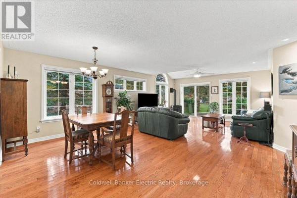 Open-concept living and dining area with hardwood floors, large windows, and multiple seating areas. - 35 - 300 Franmor Drive, Peterborough