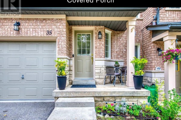 Covered front porch of townhouse 35 with seating, plants, and a garage door. - 35 - 5260 Mcfarren Boulevard, Mississauga