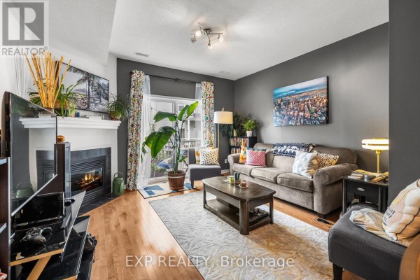 Living room with a gas fireplace, dark grey walls, a sofa, coffee table, and balcony access. - 35 - 957 Cummings Avenue, Ottawa